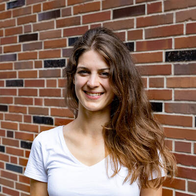 Moderatorin Anna Scheffold Portrait Moderatorin Anna Scheffold stehendes Portrait vor Backsteinwand