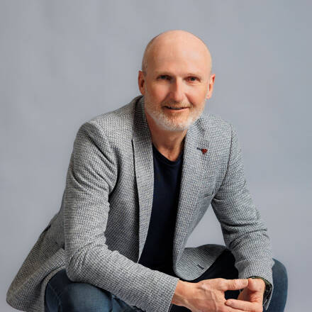 Bernhard Taurer, Geschäftsführer feratel development center, Portrait sitzend auf einer weißen Kiste in einem Foto Studio